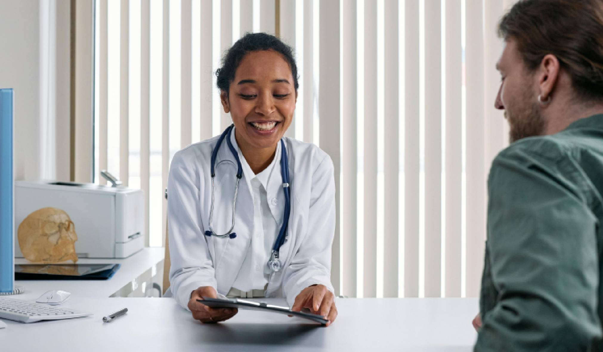 A doctor in conversation with a Merck representative