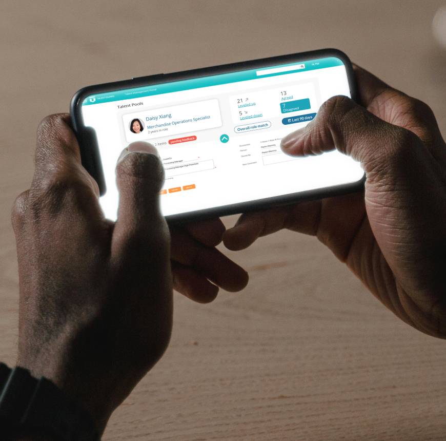A person engaged with a mobile phone, accessing TalentGuard's Web App