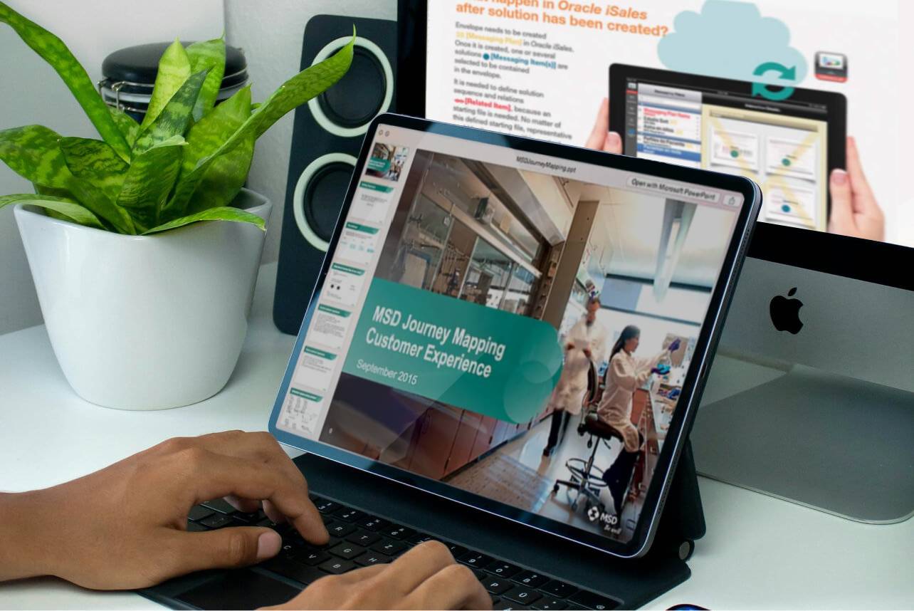 A presenter showcasing two informative slides featuring Merck's processes